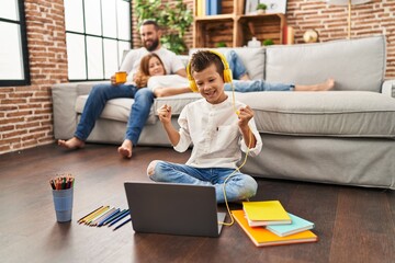 Family of three doing homework at home screaming proud, celebrating victory and success very excited with raised arm