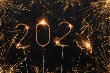 Happy New Year 2023 Silvester party card. Digits of year 2023 made by golden burning sparklers with...