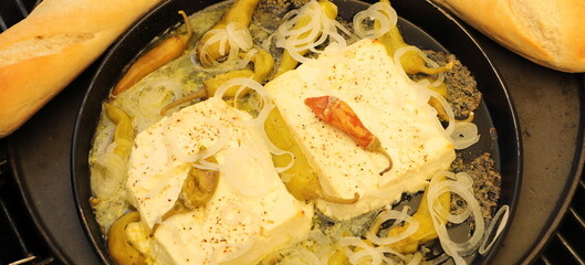 Baked feta cheese with pepperoni and onions