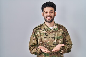 Arab man wearing camouflage army uniform smiling with hands palms together receiving or giving...