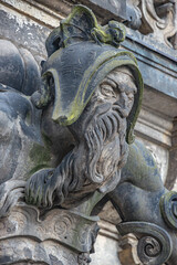 Ancient big statute of scary, fearful and heavy armed gatekeeper, medieval warrior with weapon in historical downtown of Dresden, Germany, details, closeup. Authentic European old architecture.