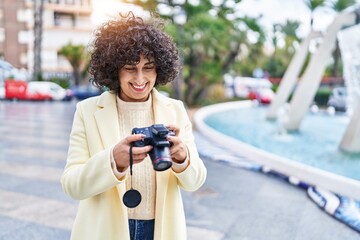 Young middle east woman excutive smiling using professional camera at park
