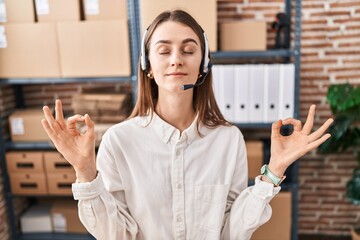 Young caucasian woman working at small business ecommerce wearing headset relax and smiling with...