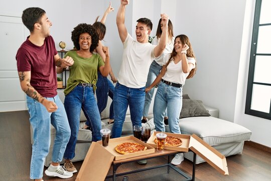 Group Of Young Friends Having Party Eating Italian Pizza And And Dancing At Home.