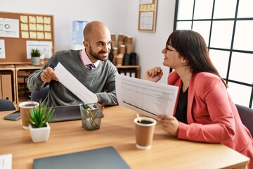 Two hispanic business workers smiling happy working at the office.