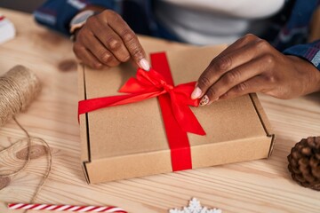African american woman ecommerce business worker preparing gift at office