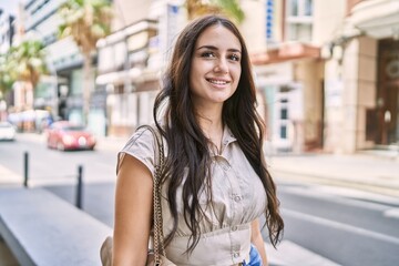 Young hispanic girl smiling happy standing at the city.