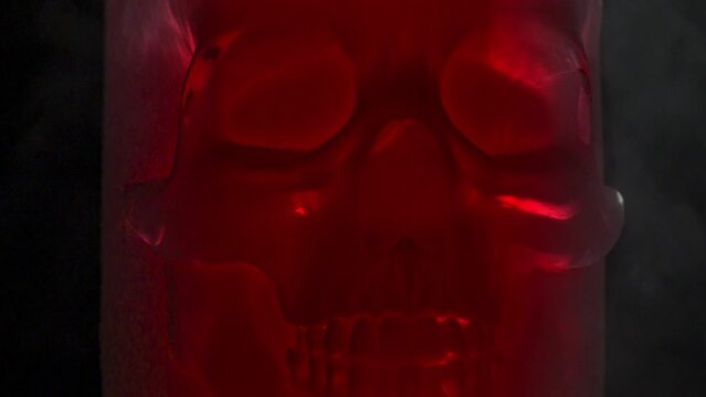 X-RAY Style Red Skull. Frosted red glass skull rotates slowly in icy vapors against black background