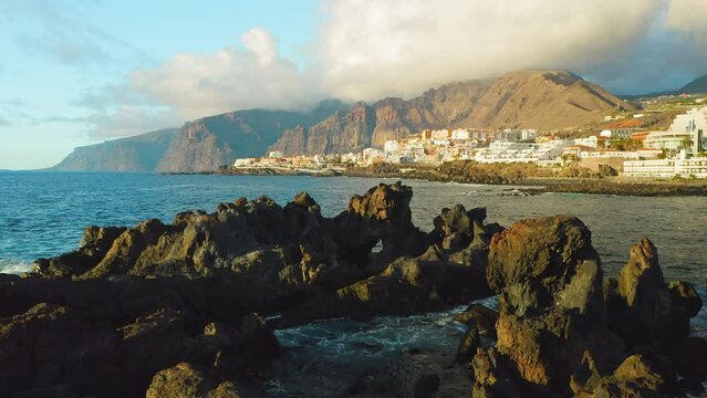 Tenerife, Canary Island, town Puerto de Santiago, Charco el Diablo or natural pool of Devil. Black lava flows, volcanic bizzare stones, rocky beach, Atlantic Ocean. Scenic spot. Amazing nature. Aerial