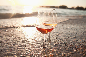 Two glasses of rose wine against the sunset sky.