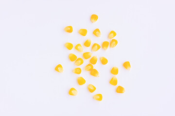 Yellow corn seeds scattered on pink background, Top view