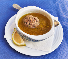  Bowl of soup with meatball on paper surface