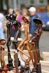 Fototapeta na wymiar Handmade wooden figurines put up for sale, street fair. Andreevsky descent. Kyiv, Ukraine