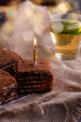 a piece of sweet strawberry pie with a cup of tea lemon and a mint leaf on a burlap on the table