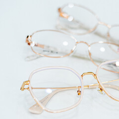 gold-rimmed eyeglasses lie on a white table