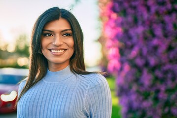 Beautiful hispanic woman smiling confient at the park