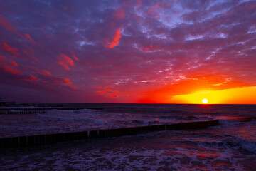 Obraz premium coast of the baltic sea with wooden breakwaters at sunset
