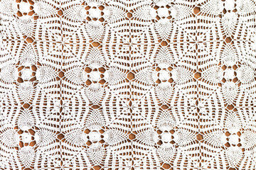 White lace pattern background on wooden table.
