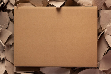 Cardboard box on torn paper  background texture. Recycling concept and brown cardboard pieces - 524850784