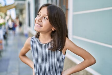 Young hispanic girl smiling outdoor at the town