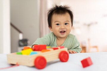 Happy little baby boy smile and enjoy with toys playing and learning to develop baby skill. Adorable Asian infant cheerful spending time at home. Baby care concept