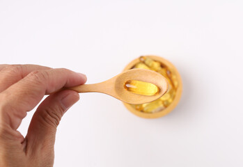 Hand hold fish oil capsules fish with omega 3 and vitamin D and supplements concept on white background