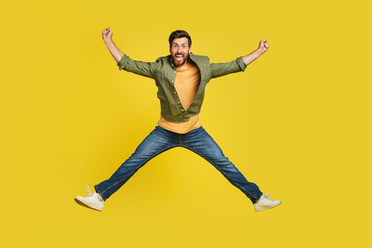 Expressing Happiness. Full Length Studio Shot Of Excited Middle Aged Man Jumping Over Yellow Background