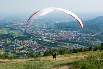 Man doing paragliding flight in the italian mountains