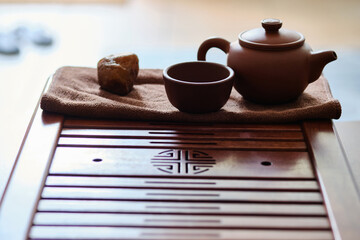 Teapot and tea cup made of yixing clay stands on a bamboo tea tray. Chinese traditional gongfu cha...