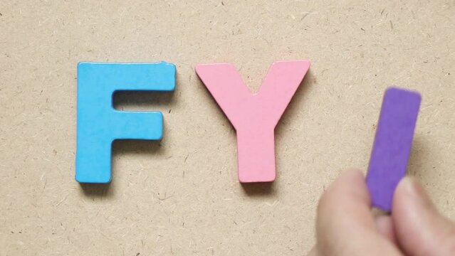 Man hold wood letter I to complete english word FYI (Abbreviation of For your information)