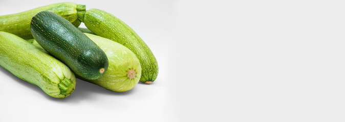 fresh zucchini on a white background. delicious green vegetables on the table. appetizing zucchini on a light texture. healthy food concept