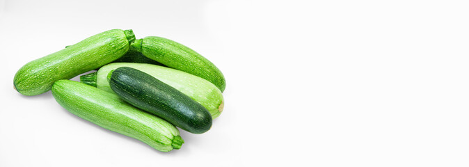 fresh zucchini on a white background. delicious green vegetables on the table. appetizing zucchini on a light texture. healthy food concept