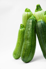fresh zucchini on a white background. delicious green vegetables on the table. appetizing zucchini on a light texture. healthy food concept