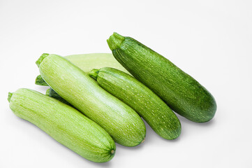 fresh zucchini on a white background. delicious green vegetables on the table. appetizing zucchini on a light texture. healthy food concept