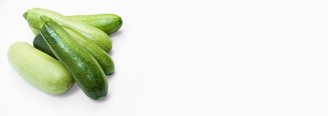 fresh zucchini on a white background. delicious green vegetables on the table. appetizing zucchini on a light texture. healthy food concept