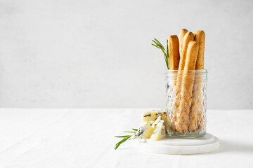 Grissini staing in glass with blue cheese, bread stick, italian traditional cuisine close