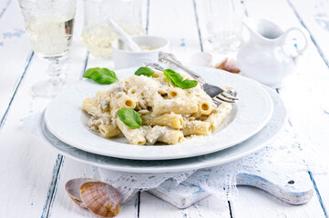 Traditional Italian pasta rigatoni al gorgonzola with vongole and cheese served as close-up on a...