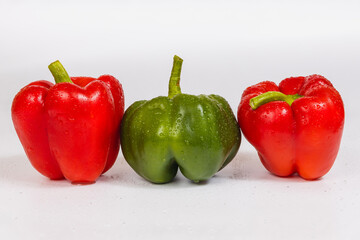 Two red green sweet peppers on a white background