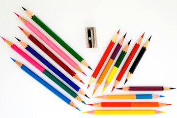 multicolored pencils for drawing and an iron sharpener on a white background