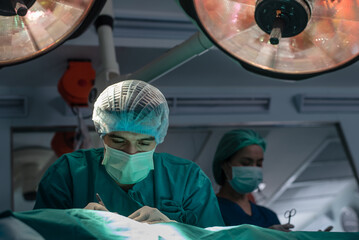 Team of professional doctors performing operation in surgery room