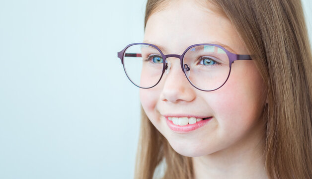 Vision correction for children. Smiling child with stylish eyeglasses on white background