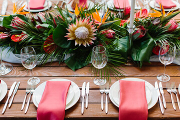 Decor and serving of a wedding banquet in a tropical style. Exotic flowers, protea, strelitzia,...