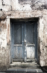 Old grey wooden door in old concrete wall, empty abstract interior, square background texture