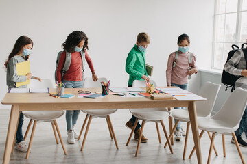 Multiracial Pupils Kids Wearing Face Masks Carrying Backpacks Entering Classroom