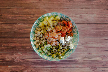 Homemade poke bowl with black Venus rice and salmon on a dark wooden table. Traditional Hawaiian dish seen from above with space for text.