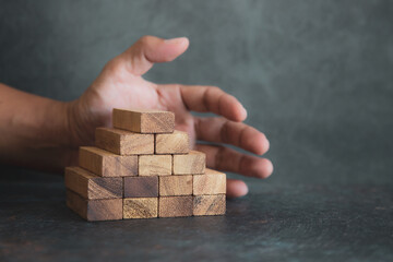 Hand place wooden block stacked concept of prevent collapse or crash of financial business and risk...