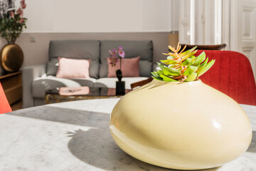 Centerpiece with an artificial plant in a living room with sofas and more plants