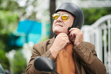 Senior Man Putting on Helmet