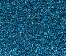Texture of the blue synthetic grass rug as a background
