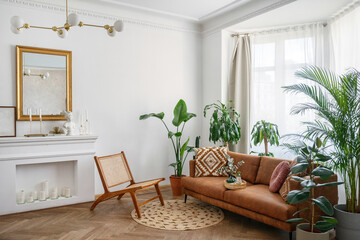 Room with brown sofa, wooden chair and potted plants